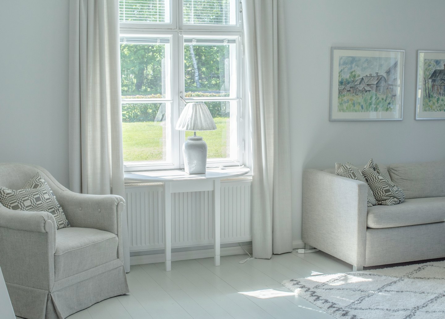 Bright living room with gray sofa and armchair by sunny window.