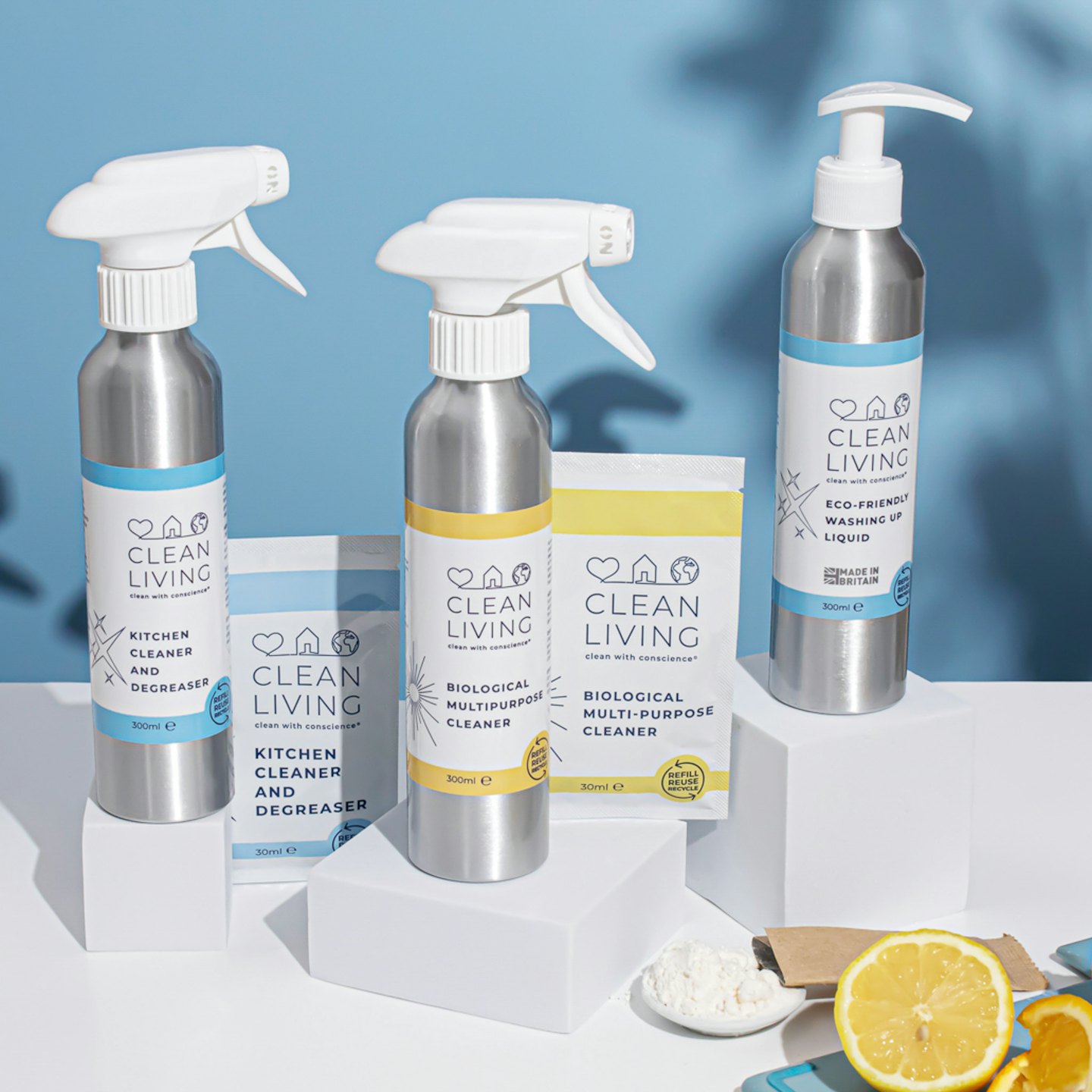 Eco-friendly cleaning supplies arranged with lemon slices on white blocks.
